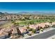 Aerial view of a sprawling community with lush golf course, desert landscaping, and scenic mountain views at 10504 Button Willow Dr, Las Vegas, NV 89134