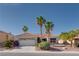 Charming home boasts a well-manicured front yard, vibrant landscaping, palm trees, and a tile roof, adding curb appeal at 10504 Button Willow Dr, Las Vegas, NV 89134