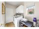 A well lit laundry room complete with appliances, storage, and a window at 10504 Button Willow Dr, Las Vegas, NV 89134