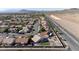 This aerial view shows neighborhood with the desert in the background; the home has outdoor seating, playground, and desert landscaping at 1079 Oak Shade Ln, Henderson, NV 89015