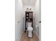 Small powder room with dark wood cabinet above the toilet and wood look flooring at 1079 Oak Shade Ln, Henderson, NV 89015