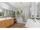 Well-lit bathroom with double sinks, soaking tub, and glass-enclosed shower at 1079 Oak Shade Ln, Henderson, NV 89015