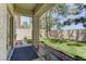 Covered patio area leading to a grassy backyard with lush trees and privacy fence at 108 Broken Rock Dr, Henderson, NV 89074