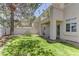 Manicured backyard with green grass, trees and patio area of a 2-story home at 108 Broken Rock Dr, Henderson, NV 89074