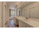 Bright bathroom featuring double vanity sinks, white tile, and large mirror at 108 Broken Rock Dr, Henderson, NV 89074