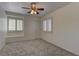 Bright bedroom featuring neutral carpet, a ceiling fan, and windows with white shutters at 108 Broken Rock Dr, Henderson, NV 89074