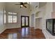 Stunning living room with beautiful hardwood floors, a fireplace, a ceiling fan, and large windows bringing in light at 108 Broken Rock Dr, Henderson, NV 89074