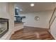 Open-concept living room featuring a modern fireplace, hardwood floors, and a kitchen with a dark range hood at 108 Broken Rock Dr, Henderson, NV 89074