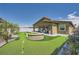 Inviting backyard features a lush putting green, comfortable patio seating, and stylish desert landscaping at 12438 Heritage Bend Dr, Las Vegas, NV 89138