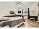 Well-lit bedroom with a gray and black color scheme features a ceiling fan, light wood floors, and ample natural light at 12438 Heritage Bend Dr, Las Vegas, NV 89138