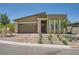 Inviting single story home with desert landscaping, brick driveway, and a two-car garage at 12438 Heritage Bend Dr, Las Vegas, NV 89138
