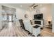 Bright living room with wood-look floors, white accent walls, and a modern fireplace at 12438 Heritage Bend Dr, Las Vegas, NV 89138