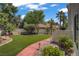 Spacious backyard featuring an artificial grass lawn, walkway and mature landscaping at 1305 Chaparral Summit Dr, Las Vegas, NV 89117