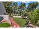 Backyard with a grass lawn and a walkway with landscaping on either side at 1305 Chaparral Summit Dr, Las Vegas, NV 89117