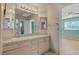 Well-lit bathroom featuring a dual sink vanity, large mirror, and a doorway leading to another room at 1305 Chaparral Summit Dr, Las Vegas, NV 89117