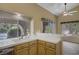 Bright kitchen with tile countertops, a double sink, and a view to the outdoor spaces at 1305 Chaparral Summit Dr, Las Vegas, NV 89117