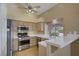 Well-lit kitchen featuring stainless steel appliances, tile countertops, and a breakfast bar at 1305 Chaparral Summit Dr, Las Vegas, NV 89117