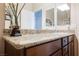 Neutral bathroom vanity with a granite countertop and framed mirrors at 132 Soaring Sky Ave, Henderson, NV 89011