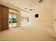 Well-lit bedroom with neutral carpet, ceiling fan, and access to the backyard at 2017 Eagle Trace Way, Las Vegas, NV 89117