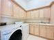 Well-lit laundry room with ample cabinet space, washer, and dryer at 2017 Eagle Trace Way, Las Vegas, NV 89117