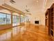 Open living room area featuring custom built-ins, fireplace, large windows, and wood floors at 2017 Eagle Trace Way, Las Vegas, NV 89117