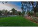Wide backyard has a well-manicured lawn, mature trees, and patio seating at 2222 Lucerne Ct, Henderson, NV 89014