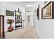 Hallway with neutral carpet, and decorative shelves and artwork at 2222 Lucerne Ct, Henderson, NV 89014