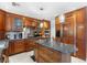 Gourmet kitchen featuring wood cabinets, granite countertops, stainless steel appliances, and a center island with seating at 2222 Lucerne Ct, Henderson, NV 89014
