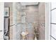 Modern walk-in shower with gray stone tiles, a glass door, and a built-in bench at 2222 Lucerne Ct, Henderson, NV 89014