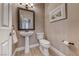 Cozy half-bath with a pedestal sink, toilet, and decorative mirror and artwork at 2544 Ashley Rose Ter, Henderson, NV 89052
