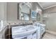 Stylish main bathroom featuring a dual vanity, mirrors, decorative tiles, and a glass-enclosed shower at 2544 Ashley Rose Ter, Henderson, NV 89052