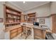 Detailed home office with built-in shelves, exposed-brick accents, dual work stations, and wood floors at 2544 Ashley Rose Ter, Henderson, NV 89052