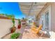 Covered patio with an outdoor fireplace, lounge chairs, and view of the backyard and neighborhood at 2544 Ashley Rose Ter, Henderson, NV 89052
