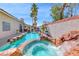 Beautiful in-ground pool and spa featuring rock detail and lush tropical landscaping, perfect for relaxation at 2544 Ashley Rose Ter, Henderson, NV 89052