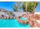 Relaxing pool with a jacuzzi and rock waterfall, surrounded by lush landscaping and palm trees at 2544 Ashley Rose Ter, Henderson, NV 89052