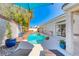 Inviting pool with a rock waterfall feature, clear blue water, and surrounded by palm trees at 2544 Ashley Rose Ter, Henderson, NV 89052