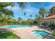 Community pool and spa surrounded by lush landscaping, palm trees, and mature trees at 3135 S Mojave Rd # 113, Las Vegas, NV 89121