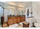 Bathroom featuring double sinks with wooden cabinets, large mirrors, and designer wallpaper at 3355 Royal Bay Dr, Las Vegas, NV 89117