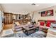 Spacious living room open to the kitchen with hardwood floors and comfortable brown sectional sofa at 3355 Royal Bay Dr, Las Vegas, NV 89117