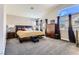 Spacious main bedroom with a cozy bed, large windows, and soft carpet for ultimate comfort at 3355 Royal Bay Dr, Las Vegas, NV 89117