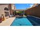 Backyard pool and covered patio with comfortable seating and waterfall feature at 3355 Royal Bay Dr, Las Vegas, NV 89117