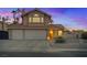 Charming two-story home featuring a three-car garage and desert landscaping at sunset at 353 Templeton Dr, Henderson, NV 89074