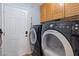 Laundry room featuring a full size washer and dryer, wooden cabinets, and a back door at 353 Templeton Dr, Henderson, NV 89074