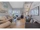 Bright living room featuring hardwood floors, a staircase, and large windows with shutters at 353 Templeton Dr, Henderson, NV 89074