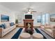 Bright living room featuring a fireplace, ceiling fan, and large windows for natural light at 353 Templeton Dr, Henderson, NV 89074