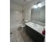Bright bathroom featuring a combination tub and shower, modern vanity and ample lighting at 3585 Arville St # 403A, Las Vegas, NV 89103