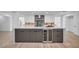 Kitchen island with a marble countertop, gray cabinetry, and a built-in wine cooler, perfect for entertaining at 3630 Tobias Ln, Las Vegas, NV 89120
