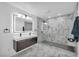Sleek main bathroom boasts luxurious marble tile, dual vanity and glass enclosed shower at 3630 Tobias Ln, Las Vegas, NV 89120
