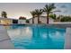 Tranquil pool reflecting a modern home with palm trees at dusk at 3630 Tobias Ln, Las Vegas, NV 89120