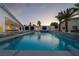 A backyard oasis with a sparkling pool, palm trees, and a modern home design at 3630 Tobias Ln, Las Vegas, NV 89120